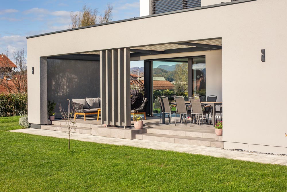 Modernes Lamellendach als architektonische maßgeschneiderte Lösung für die Terrasse eines zeitgemäßen Einfamilienhauses